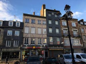a group of buildings on a city street with cars at Sur les Toits de Honfleur in Honfleur