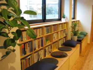 a row of book shelves filled with books at Guesthouse Hyakumanben Cross in Kyoto