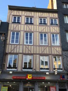 a large building with windows on a city street at Sur les Toits de Honfleur in Honfleur