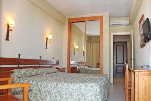a bedroom with two beds and a mirror at Al Sur de Chipiona in Chipiona