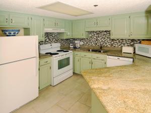 een keuken met groene kasten en witte apparaten bij Phoenix East Unit 607 in Orange Beach