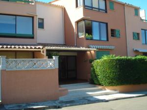 une grande maison avec une haie en face dans l'établissement Le Galion, au Grau-dʼAgde