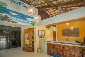 a bar in a restaurant with a surfboard on the wall at Back Door Village in Olivença