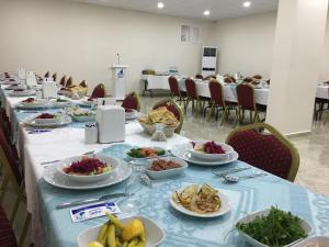 ein langer Tisch mit Tellern voller Essen darauf in der Unterkunft Avesis Hotel in Nusaybin