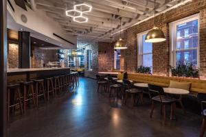 un bar con sillas, mesas y paredes de ladrillo en Hotel Hive en Washington