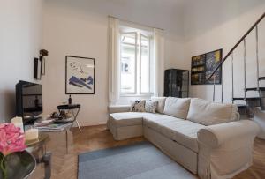 ein Wohnzimmer mit einer weißen Couch und einem Fenster in der Unterkunft Old Bridge: historical and chic apartment in Florenz