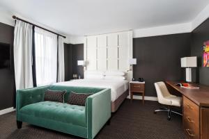 a hotel room with a bed and a green couch at The Commonwealth in Richmond