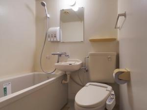 a bathroom with a toilet and a sink and a bath tub at APA Hotel Gifu Hashima Ekimae in Hashima