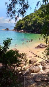 a group of people in the water at a beach at Dolce Mar Ubatuba Suites in Ubatuba