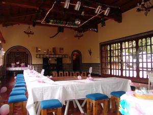 um quarto com uma mesa longa e cadeiras azuis em Casa Madero Rooms em Cuernavaca