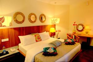 a bedroom with a bed and a desk and mirrors at Hotel Villa Highnest - Oragadam -Sriperumbudur in Sriperumbudur