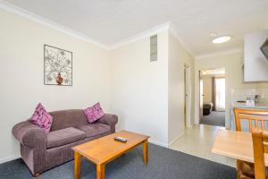 a living room with a couch and a table at Werribee Motel and Apartments in Werribee