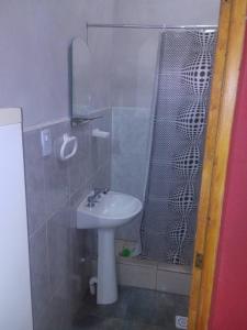 uma pequena casa de banho com um lavatório e um chuveiro em Cabañas del Dique em Termas de Rio Hondo