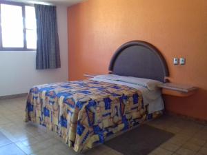 1 dormitorio con 1 cama con edredón en Promotora Hotelera Tocuila, en Texcoco de Mora