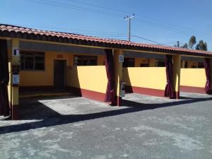 un edificio amarillo y rojo con aparcamiento en Promotora Hotelera Tocuila, en Texcoco de Mora