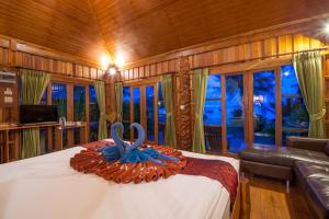 a bedroom with a bed with a blue ribbon on it at Thiwson Beach Resort - SHA Extra Plus in Ko Yao Yai