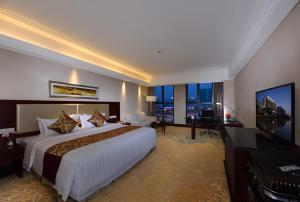 a hotel room with a large bed and a television at Kunshan International Hotel in Kunshan