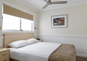 Tempat tidur dalam kamar di NRMA Stockton Beach Holiday Park