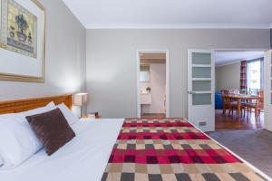 a room with a bed, a table, and a rug at Mont Clare Boutique Apartments in Perth