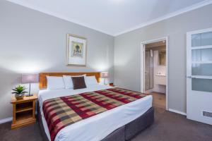 a bedroom with a large bed and a window at Mont Clare Boutique Apartments in Perth
