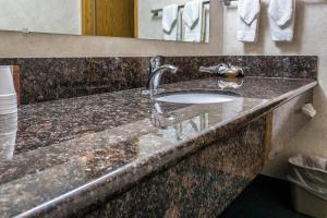 een badkamer met een granieten aanrecht met een wastafel bij Guest House Inn in Junction City