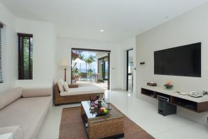 a living room with a couch and a flat screen tv at The Racha in Ko Racha Yai 
