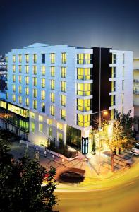 a large white building with yellow windows at night at Demora Hotel in Ankara