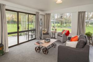 a living room with couches and a coffee table at Thistle Cottage in Ashburton