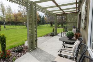een patio met een tafel en een pergola bij Thistle Cottage in Ashburton