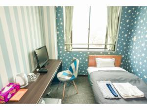 Schlafzimmer mit einem Bett und einem Schreibtisch mit einem Computer in der Unterkunft Hotel Ina in Ina
