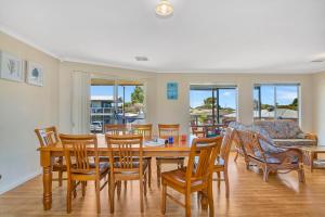 uma sala de jantar com mesa e cadeiras em Green Reef Beach House - Aldinga Beach - C21 SouthCoast Holidays em Aldinga Beach