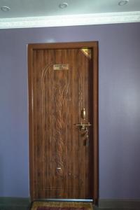 een houten deur in een kamer met een paarse muur bij Be Here Now in Kathmandu