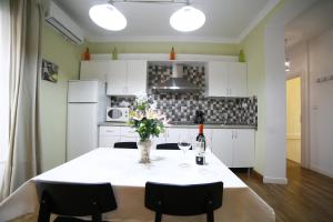 a kitchen with a table with a vase of flowers on it at Victoria de Alba House in Málaga