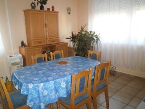 una sala da pranzo con tavolo e sedie blu di Tündérkert Apartmanok a Hajdúszoboszló Altre 9 foto