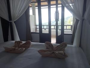 a bedroom with two bowls on a bed with a window at Puri Sunset Homestay in Munduk