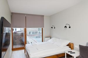 a bedroom with a bed and a large window at Apartamenty Sun & Snow Olimp Apartments in Krakow