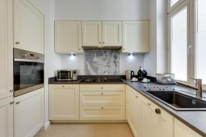 kuchnia z białymi szafkami i zlewem w obiekcie Lion Apartments - Hampton Family Apartment with two bedrooms w mieście Sopot