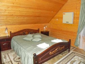 a bedroom with a bed in a wooden room at Hotel and restaurant complex Skolmo in Klevanʼ