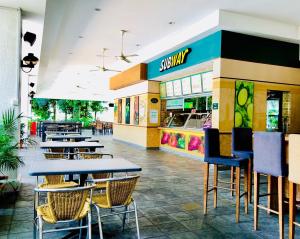 a restaurant with tables and chairs in front of a store at Orchid Country Club in Singapore