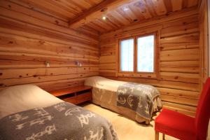 una camera con 2 letti in una baita di tronchi di Villa Levinkajo a Levi Altre 14 foto