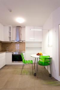 a kitchen with a table and two green chairs at MAMA PALACE in Split