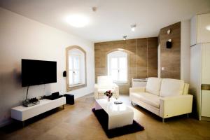 ein Wohnzimmer mit weißen Möbeln und einem Flachbildfernseher in der Unterkunft MAMA PALACE in Split