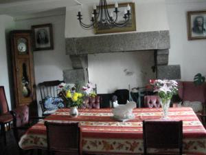 a dining room with a table with flowers on it at Ty Gwennili in Kérien