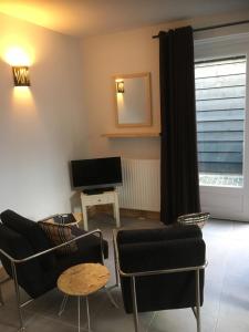ドンブルグにあるStudio voor 2 personenのリビングルーム(ソファ、椅子、テレビ付)