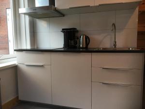 ドンブルグにあるStudio voor 2 personenの白いキャビネットとシンク付きのキッチン