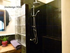a shower in a bathroom with a black tiled wall at SOUIMANGA-HOTEL in Antsirabe