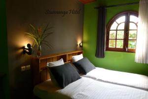 
a bedroom with a bed and a window at SOUIMANGA-HOTEL in Antsirabe
