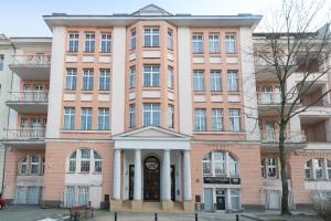 różowy budynek z zegarem w obiekcie Apart Avenue 22 w Poznaniu