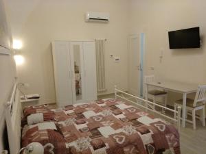 a bedroom with a bed and a table and a desk at La Maison di Nicoletta in Gaeta