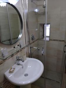 a bathroom with a sink and a shower with a mirror at La Maison di Nicoletta in Gaeta